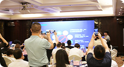 线下沙龙现场：参会者坐满会场，举起手机拍摄台上的分享